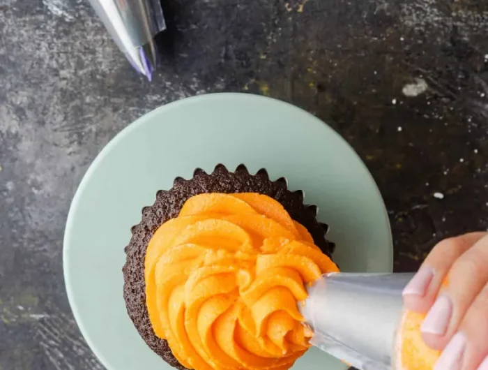 cupcake mit spritzbeutel dekorieren buttercreme orange
