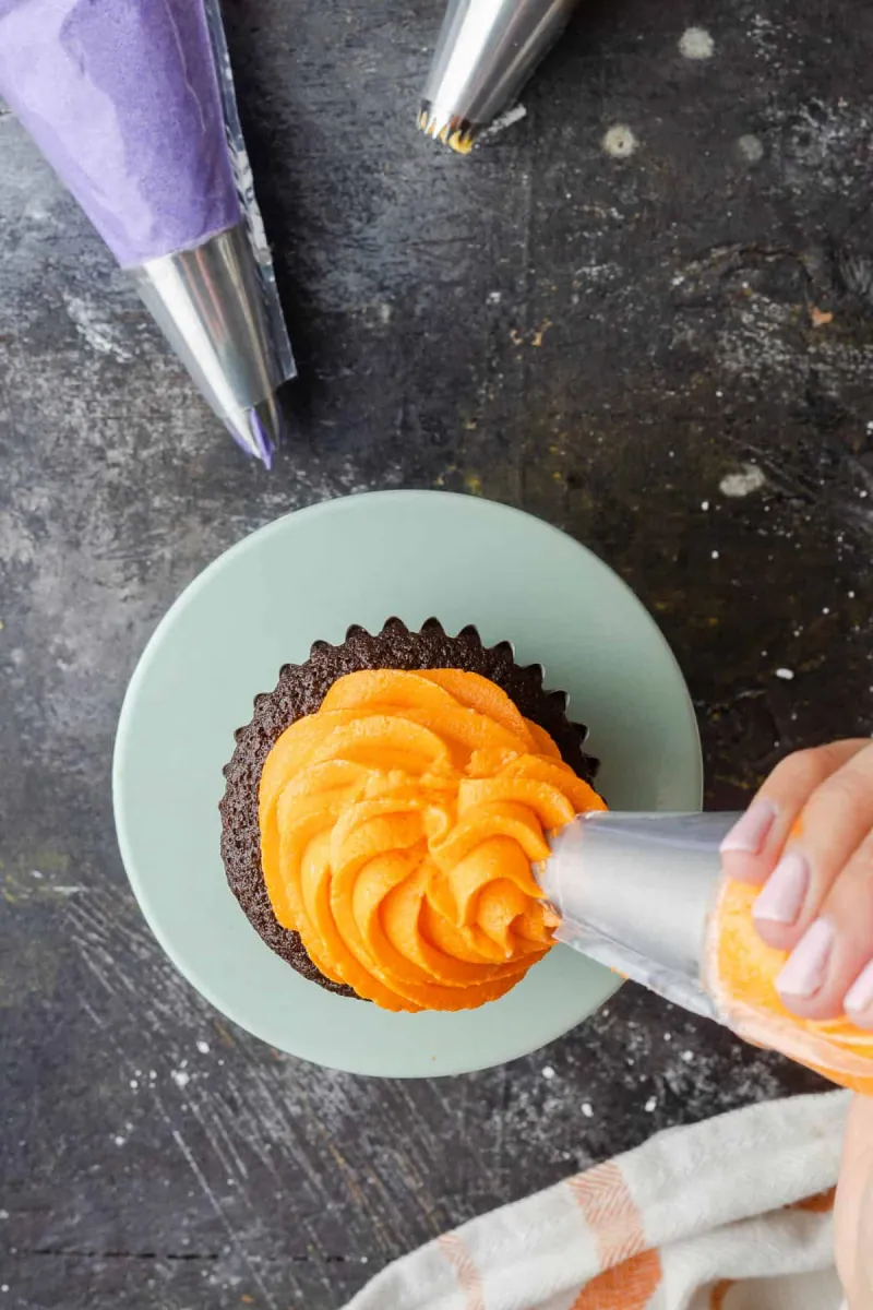 cupcake mit spritzbeutel dekorieren buttercreme orange