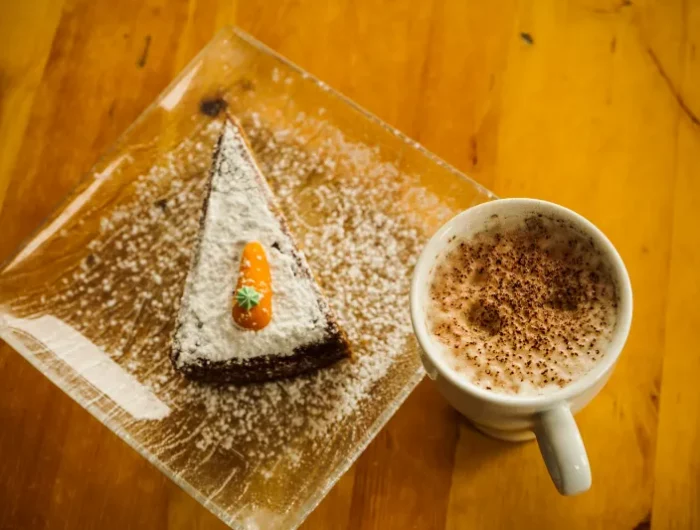 foto von einem kuchen bestreut mit puderzucker und eine tasse kaffee