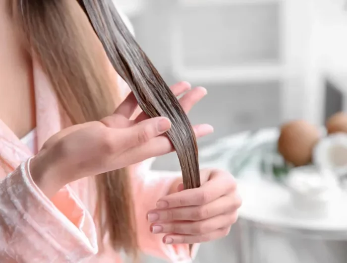 frau traegt haarmaske gegen haarausfall auf ihre haare auf haarpflege tipps