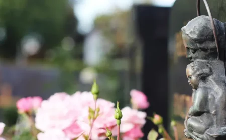 immergruene bodendecker fuer dauerhafte grabbepflanzung doppelgrab bluehende rosen grabstein mit figuren