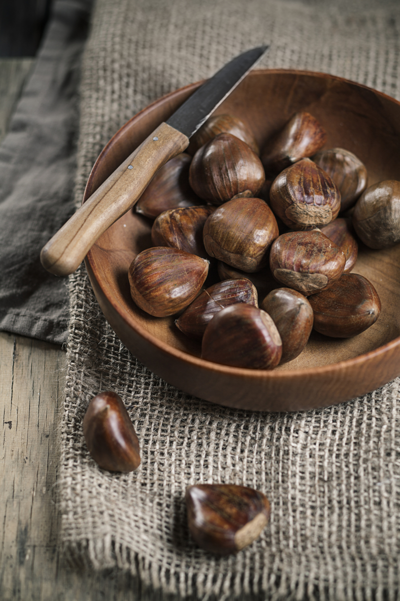 chestnuts in wooden bowl, knife on top
