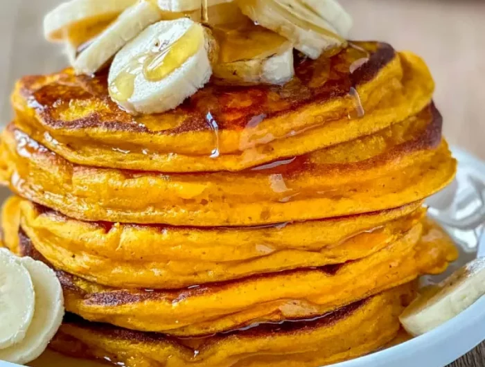 kürbis pfannkuchen garniert mit bananenscheiben und ahornsirup
