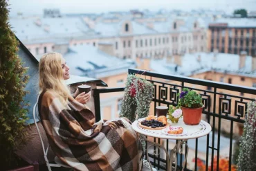 topfpflanzen draußen winterhart dame auf dem balcon mit decke und kaffee