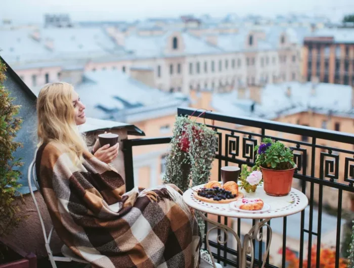 topfpflanzen draußen winterhart dame auf dem balcon mit decke und kaffee