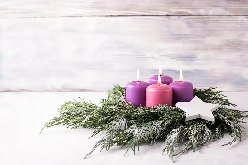 adventskranz traditionell drei violette kerzen eine rosa immergrüne zweige