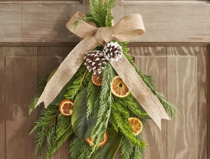 eingangstür deko für weihnachten immergrüne zweige getrocknete orangen zapfen