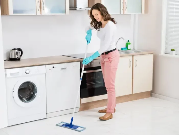 kuchenboden reinigen nur mit wasser frau reinigt weissen kuechenboden fliesen mit feuchtem wischmopp