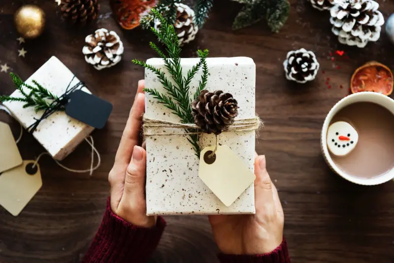 lustige kleine geschenke fuer kollegen weihnachten packet geschenk mit wessem geschenkpapier und tannenbaumzweig dekoriert