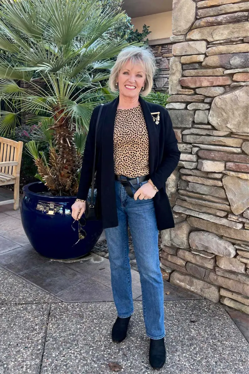 spoertlich elegante mode fuer frauen ab 60 wie ziehe ich mich mit 60 an aeltere frau mit geraden jeans dunkelblauem blazer leopard print bluze