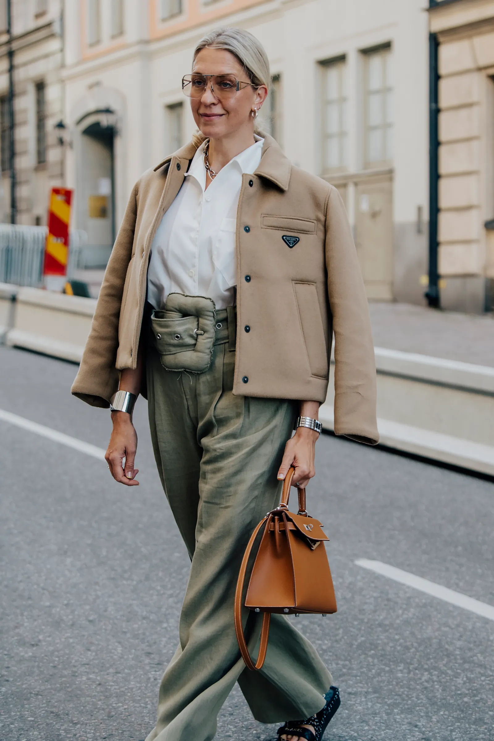 welche kleidung macht optisch schlank frau in eleganten hosen in khaki gruen mit grossem guertel beige jacke und weisser bluse