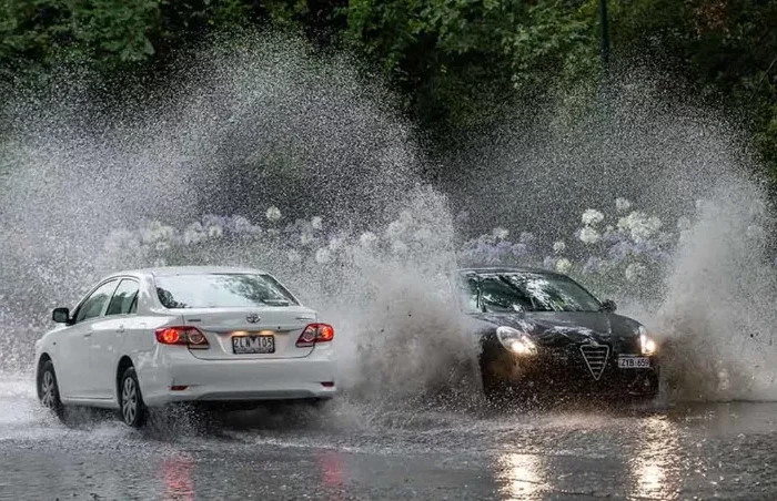 zwei autos fahren bei starkem regen