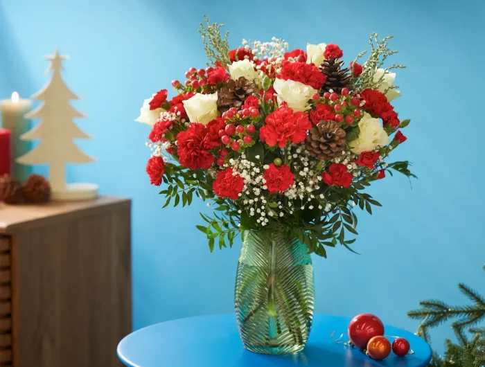 was darf man nicht zu weihnachten schenken sehr grosser strauss aus weissen und roten rosen in vase auf blauem kaffeetisch