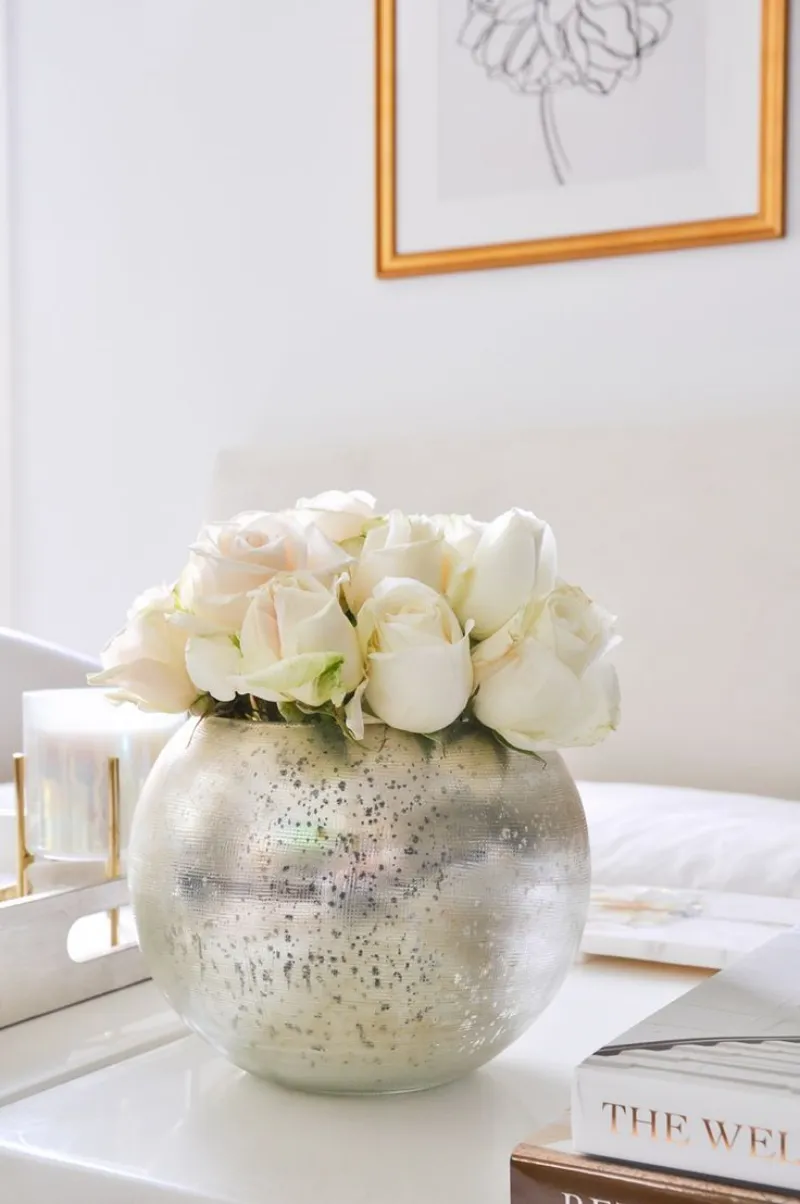 weiße rosen in runder vase bild goldener rahmen bücher