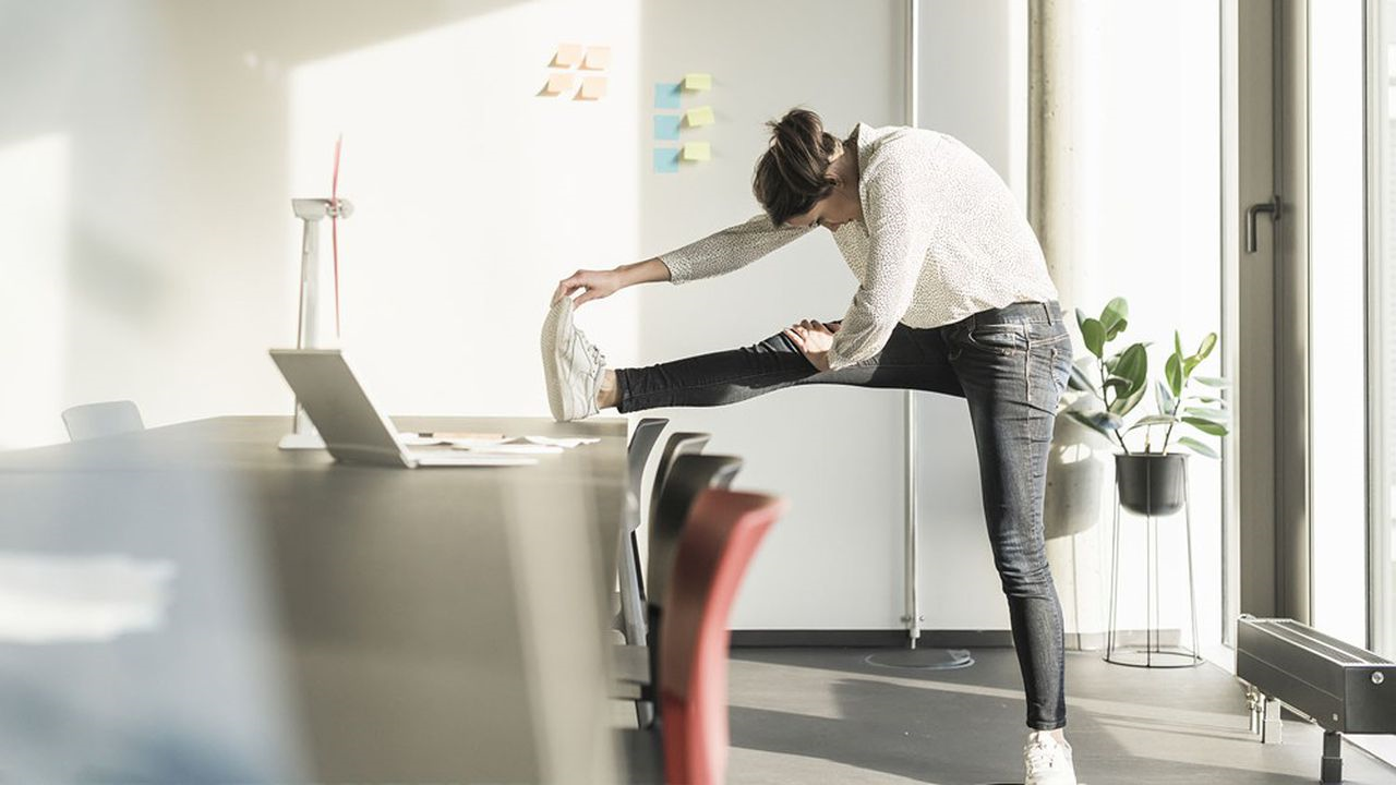 5 minuten workout anfaenger wie lange sollte manhome workouts machen frau dehnt ein bein am tisch im buero