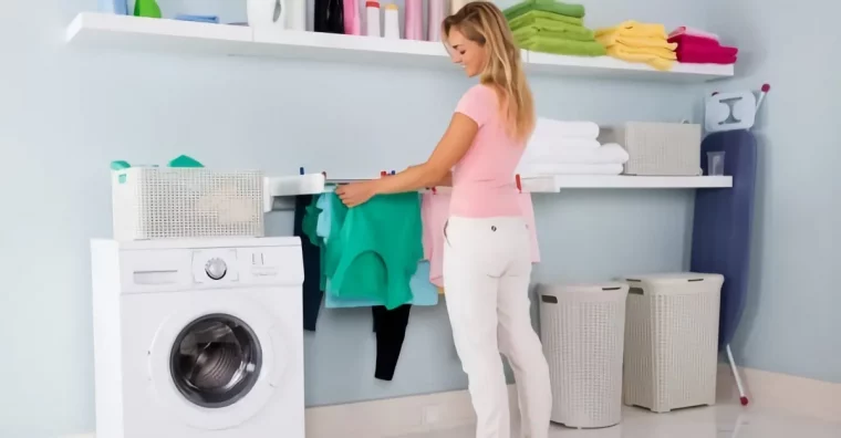 hausfrau haengt bunte waesche in der waschkueche auf