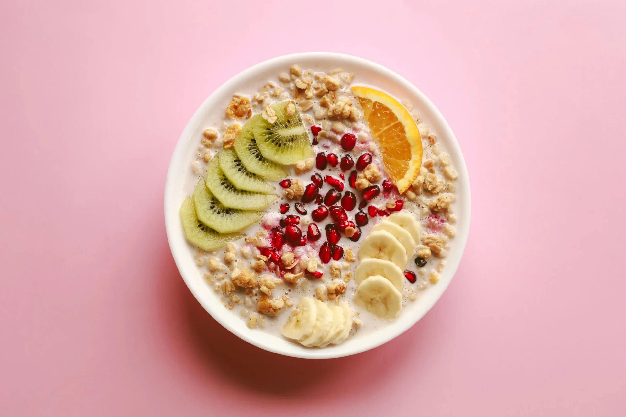 gesundes frühstück banane kiwi orange haferflocken granatspfel in milch