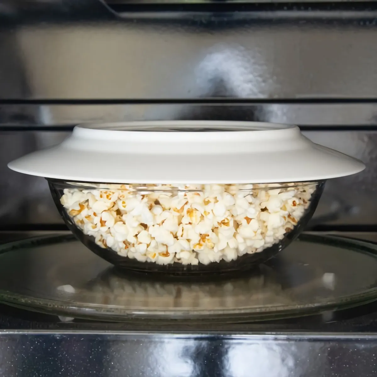 selbstgemachtes popcorn in einer schuessel in der mikrowelle