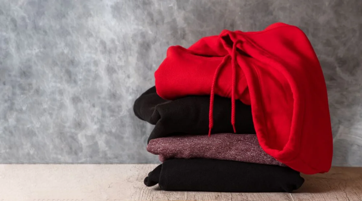 unordentlicher haufen mit kapuzenpullover roter kapuzenpullover zwei schwarze kapuzenpullover und rosa kapuzenpullover