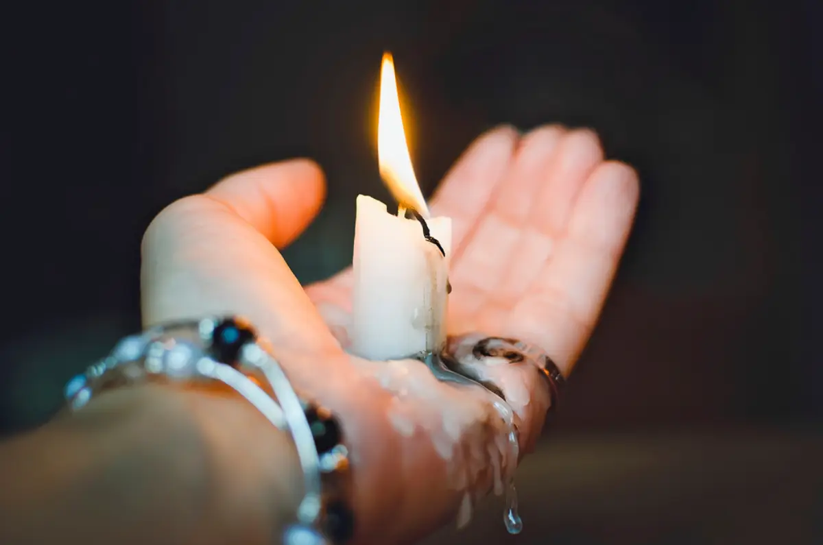 Растопленная свеча в руке