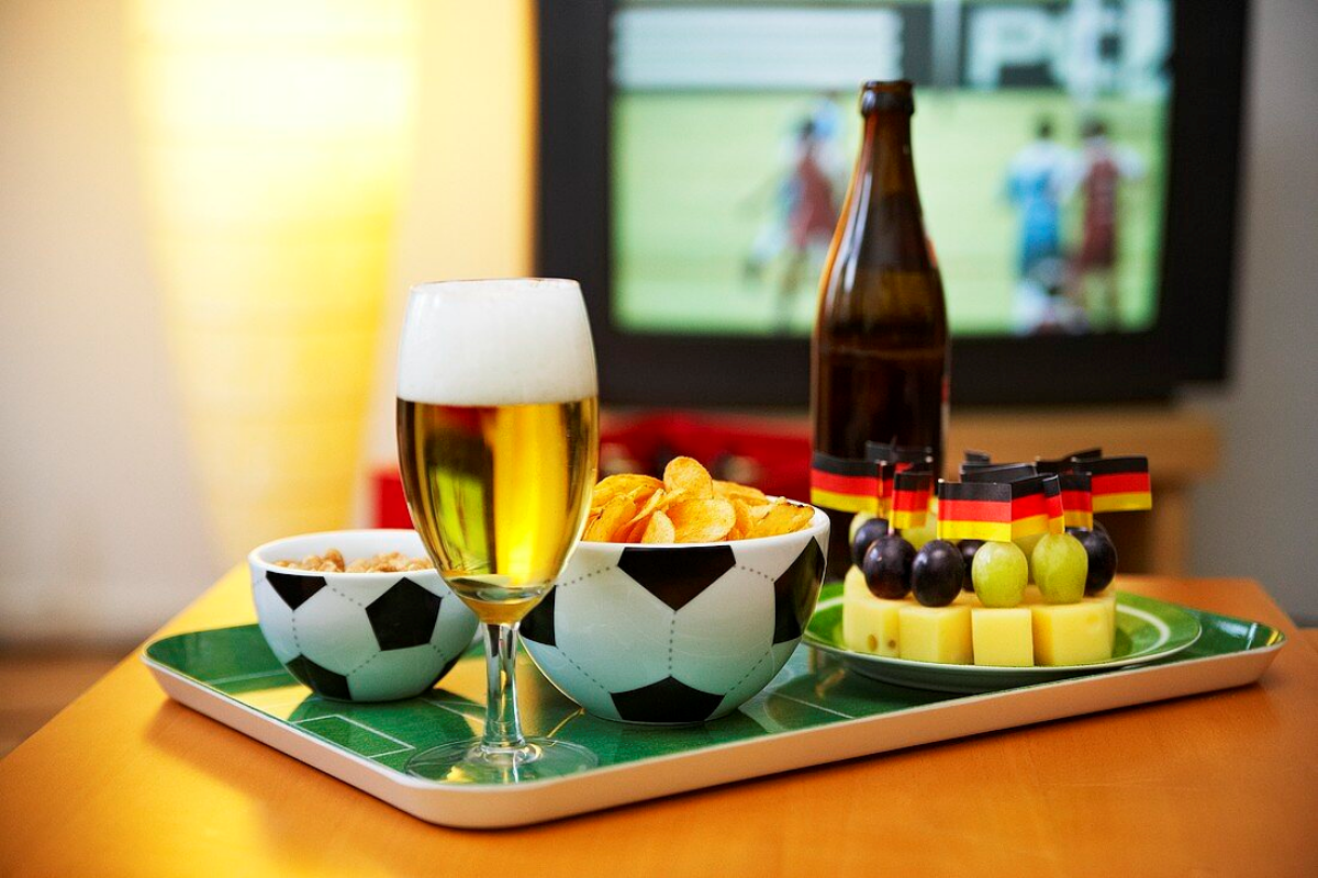 gesunde snacks abends was braucht man fuer einen gemuetlichen fernsehabend kaffeetisch tafel mit fussballbeutel chips flasche bier