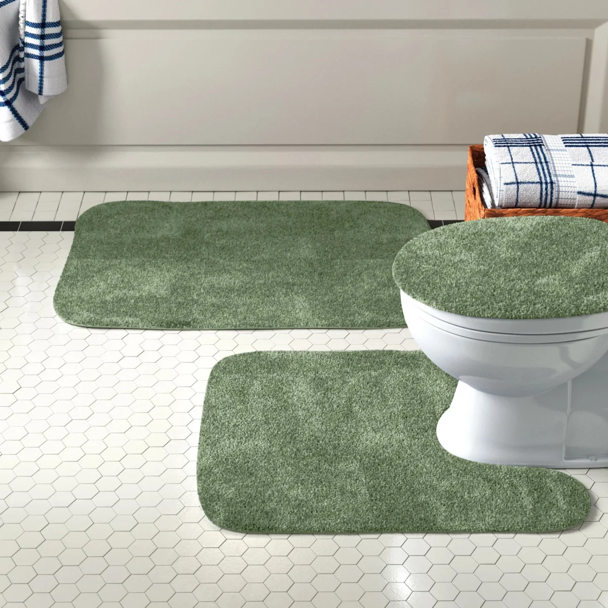 gruene teppiche auf dem fliesenboden im badezimmer vor bad und toilette
