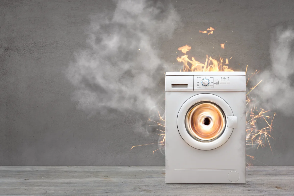 kaputte waschmaschine mit flammen und funken und feuer und rauch