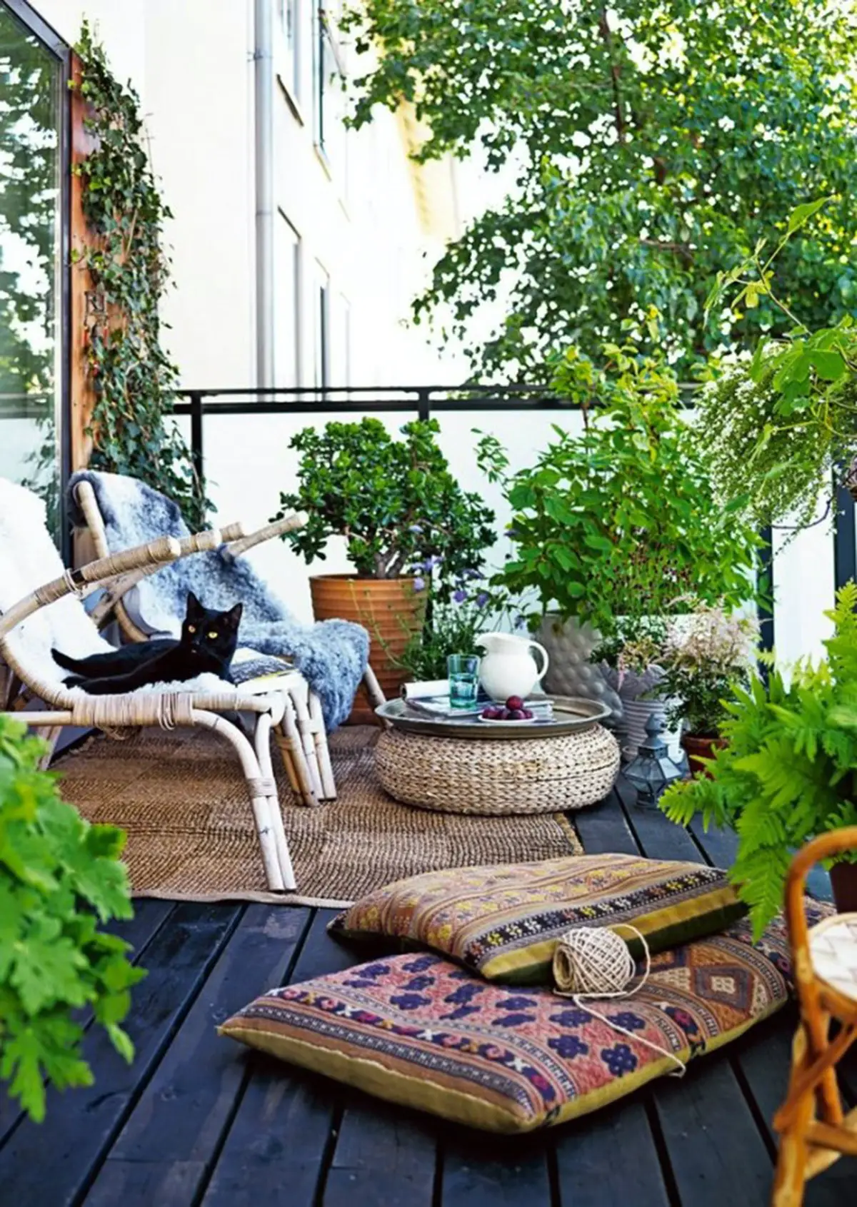 kleine ueberdachte terrasse gestalten kleine terrasse in boho stil mit sitzkissen und viele pflanzen schwarze katze am sessel