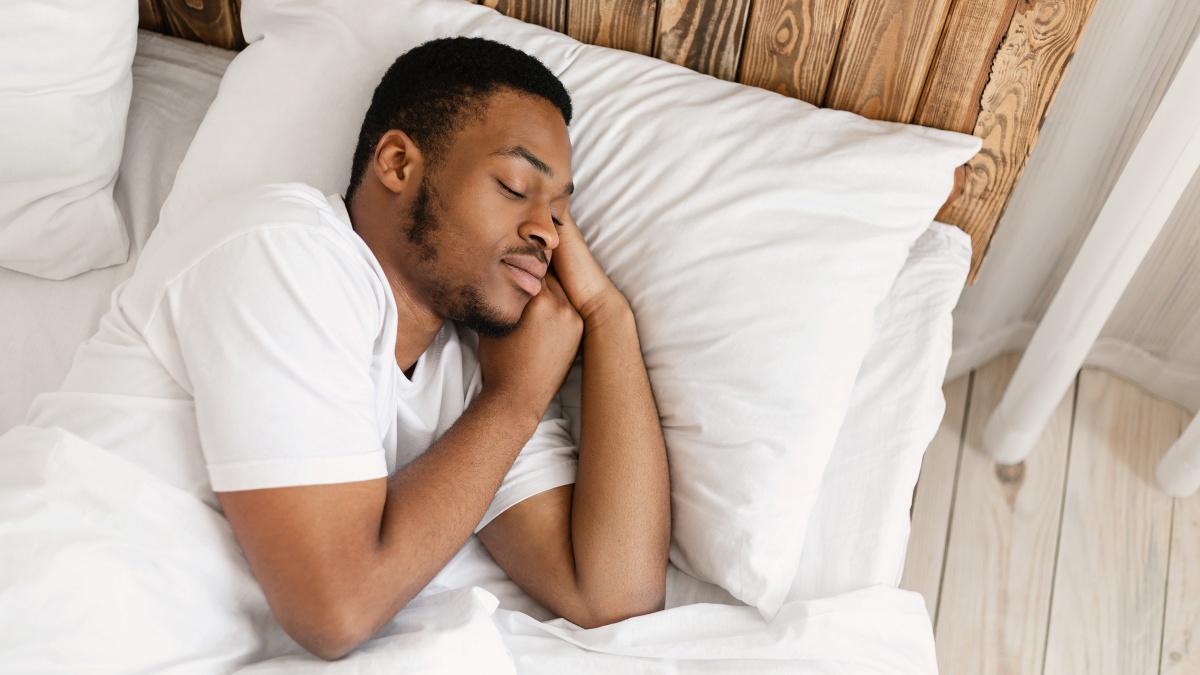 african american man sleeping peacefully in comfortable bed at home