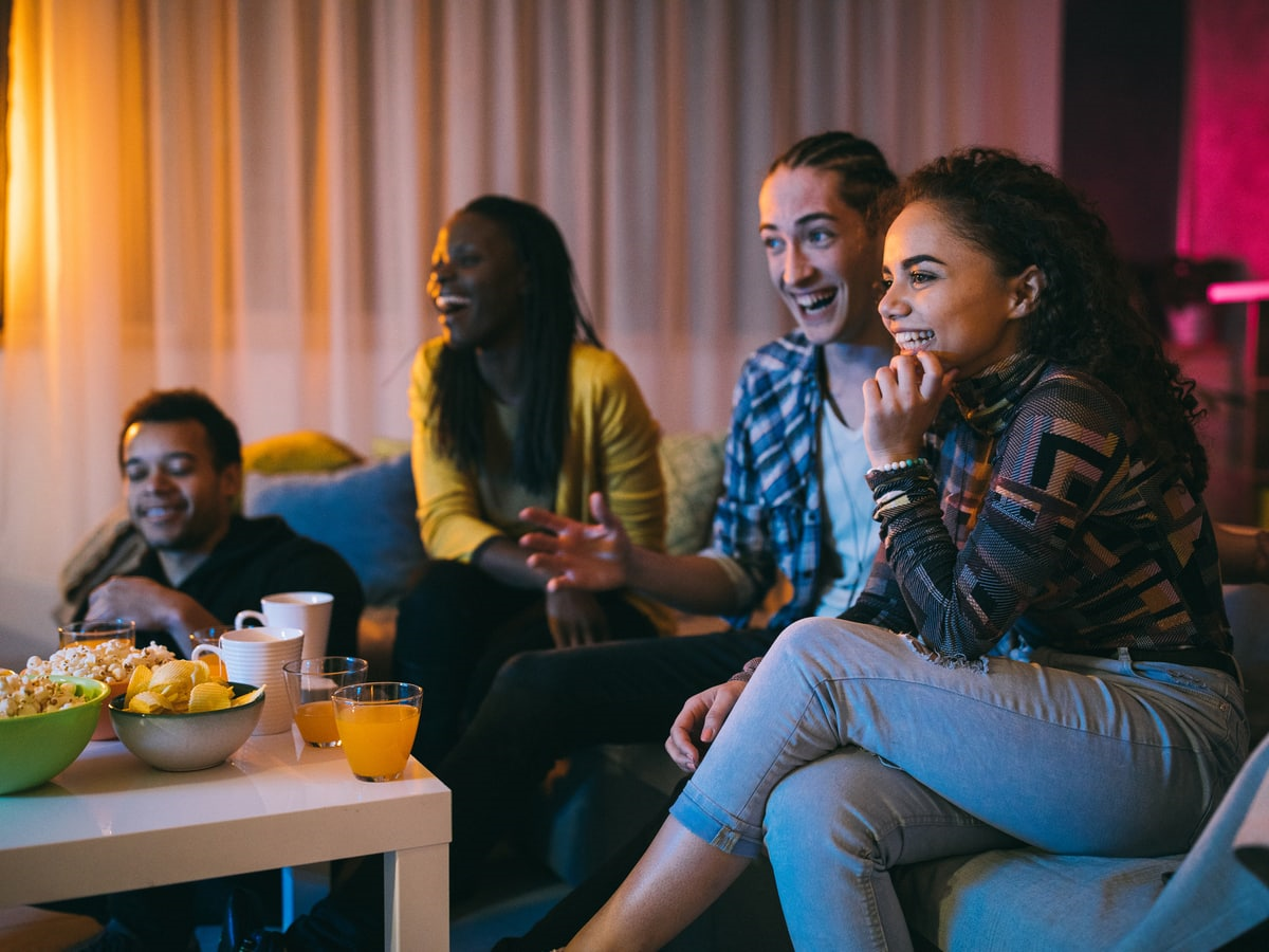 was kann man naschen ohne kalorien gesunde snacks fuer fernsehabend vier freunde drei maedchen einen jungen am sofa naschen sehen fern