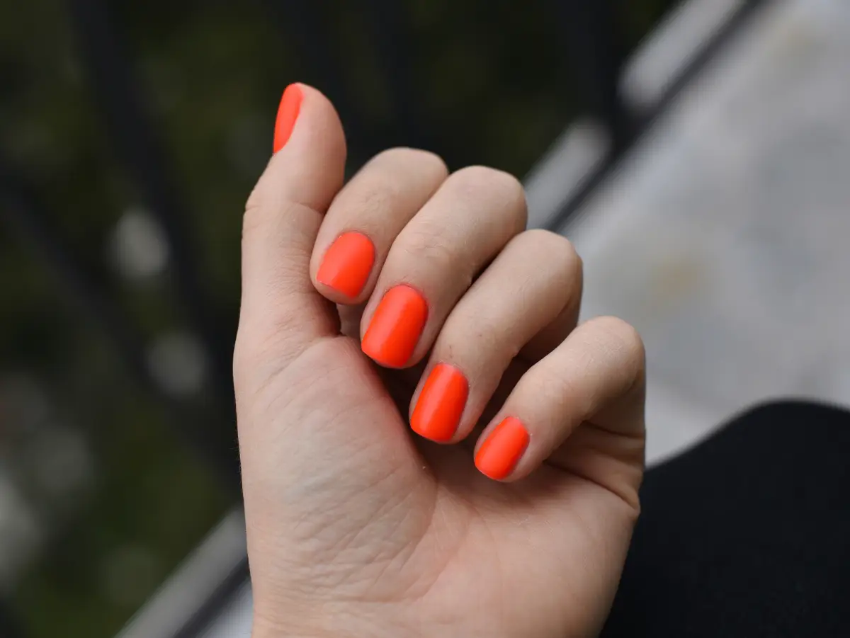 welche nagellackfarbe fier frauen ab 50 nagellack trends 2023 frau mit runden naegeln mit orangem nagellack