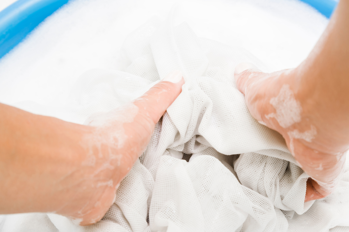 person wäscht weiße gardinen in blauem waschbecken