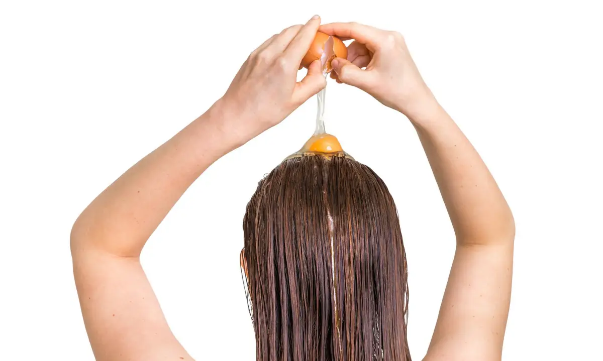 wie bekommt man natuerlich glatte haare frau mit nassem haar bricht ein ei auf dem kopf