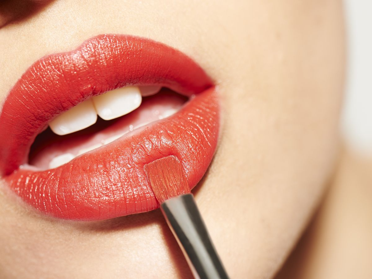 auftragen von rotem lippenstift mit einem pinsel, um den lippenstift länger haltbar zu machen