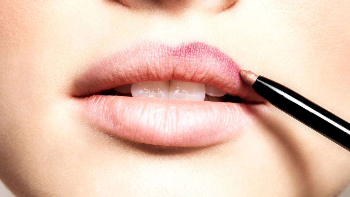 frau konturiert die lippen mit einem bleistift um den lippenstift länger haltbar zu machen