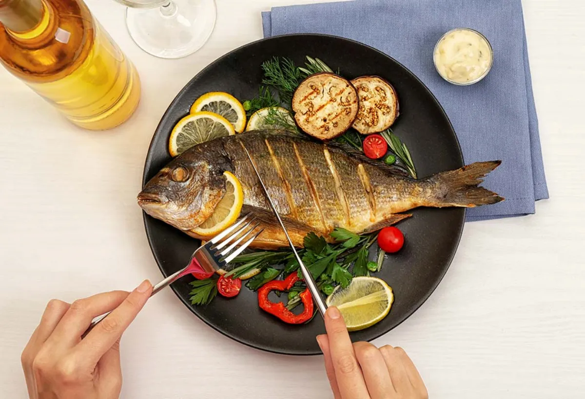 fisch essen für gesunde haut garniert mit zitronenscheiben und frischgemüse