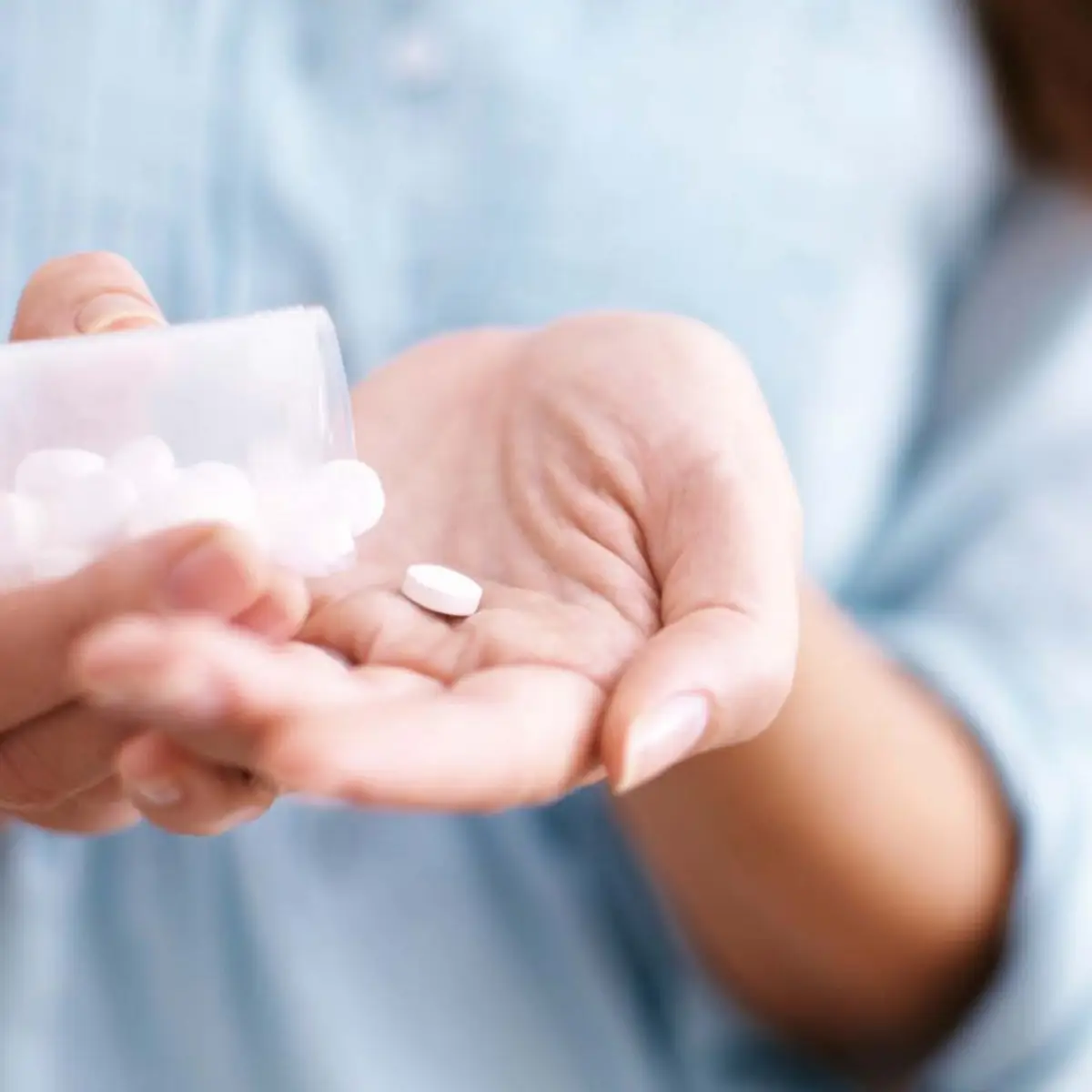 kann man betrunken aspirin nehmen frau haelt im hand eine tablette aspirin