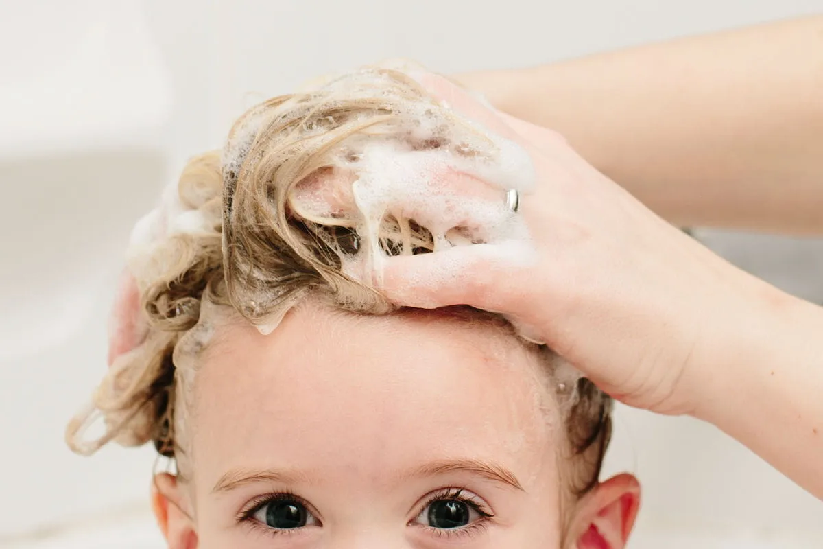 kleiner junge haare waschen blond hände frau