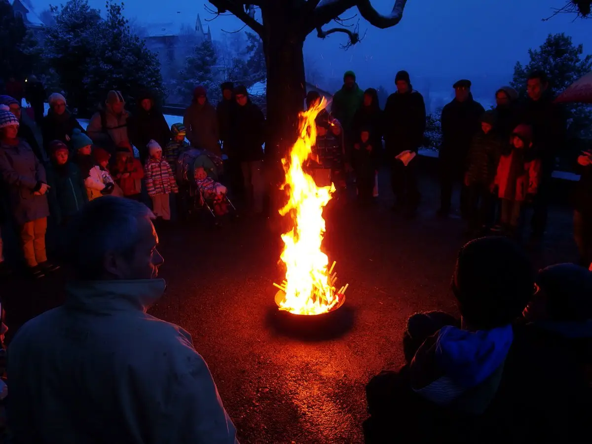 was gibt es alles fuer osterbraeuche viele leute um brennendes osterfeuer gesammelt nacht