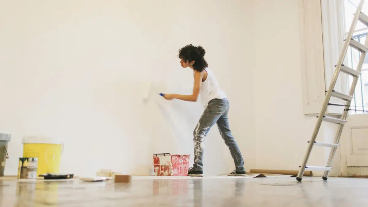 wie streicht man eine wand gleichmaessig frau streicht wand selbst in weiss