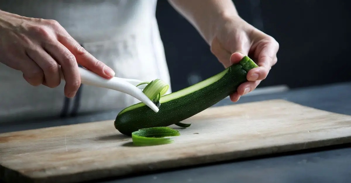 zucchini roh essen als salat man schneidet zucchini mit spiralschneider