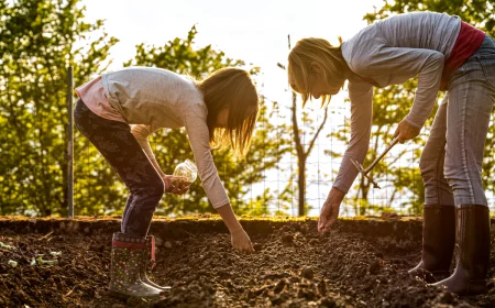 mutter und tochter säen pflanzen im garten im juni