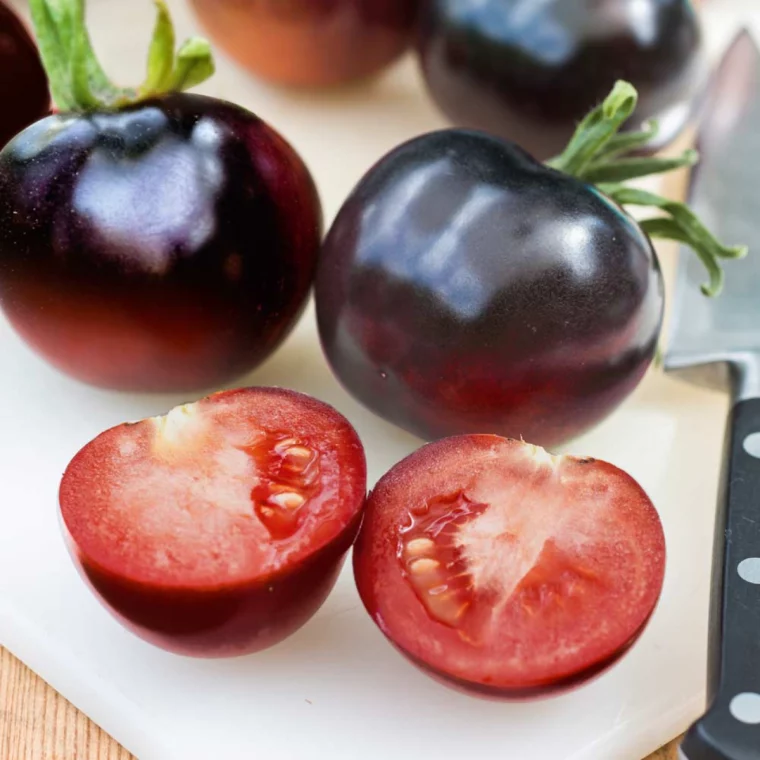 zwei reife schwarze tomaten die aufgeschnitten sind