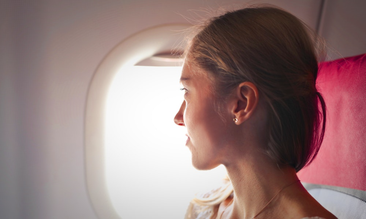 frau sitzt im flugzeug und bleibt während der turbulenzen ruhig