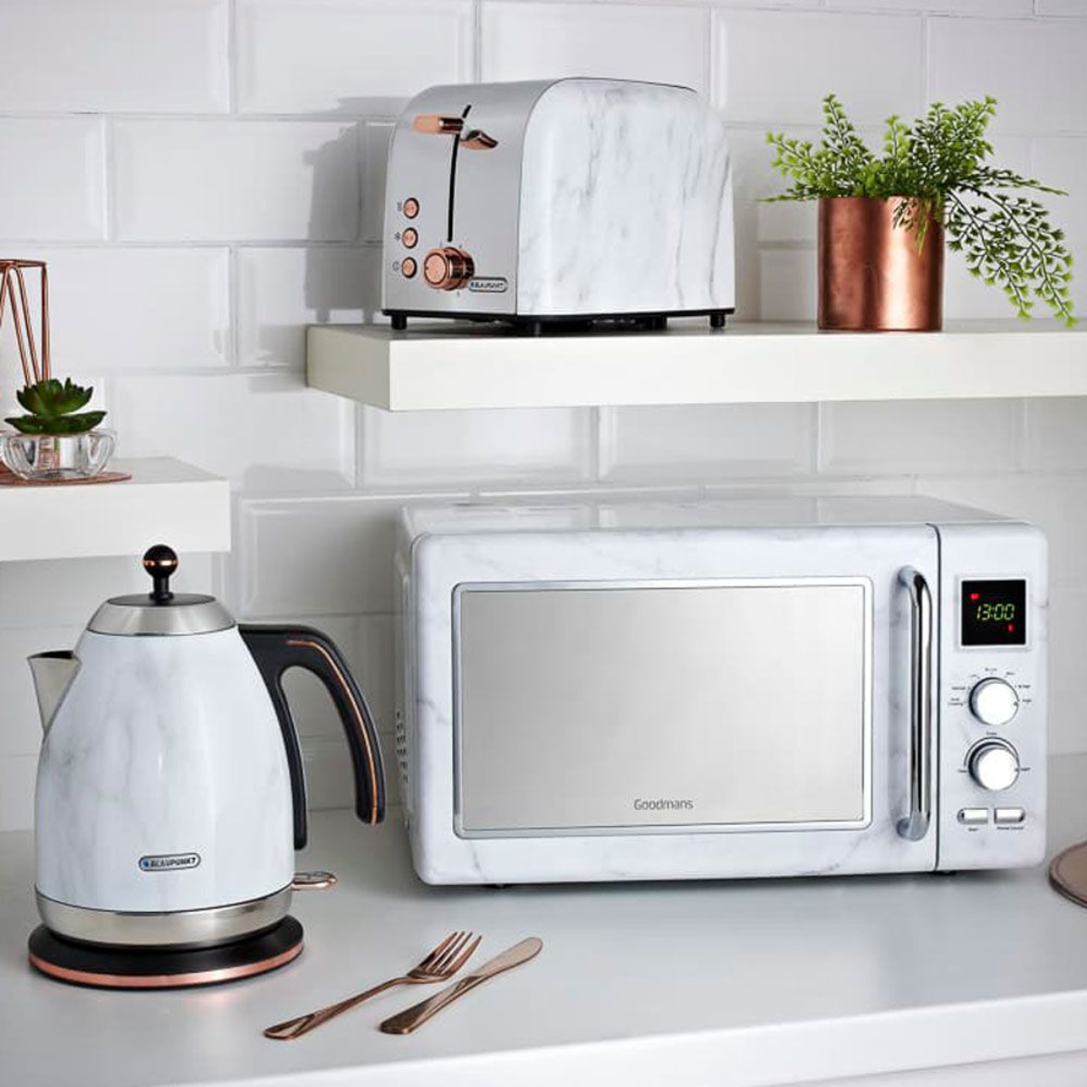 wasserkocher mikrowelle und toaster in weiß und kupferfarben auf weißer theke