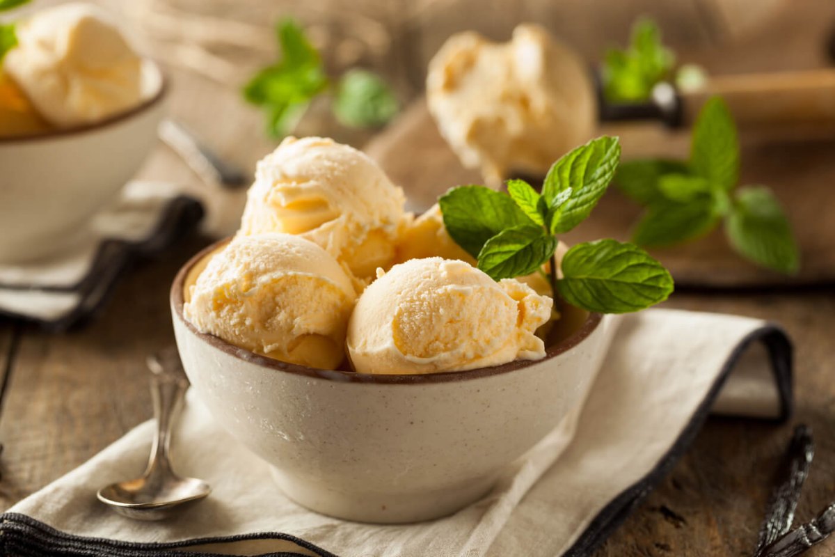 gelbes italienisches gelato in beiger schale serviert mit minze