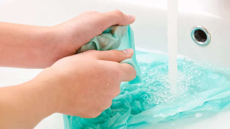 behandlung von kleidung mit flecken von sonnencreme auf dem waschbecken