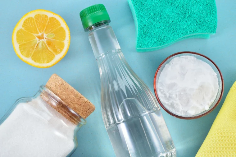 flasche mit essig natron salz zitrone und blauem schwamm