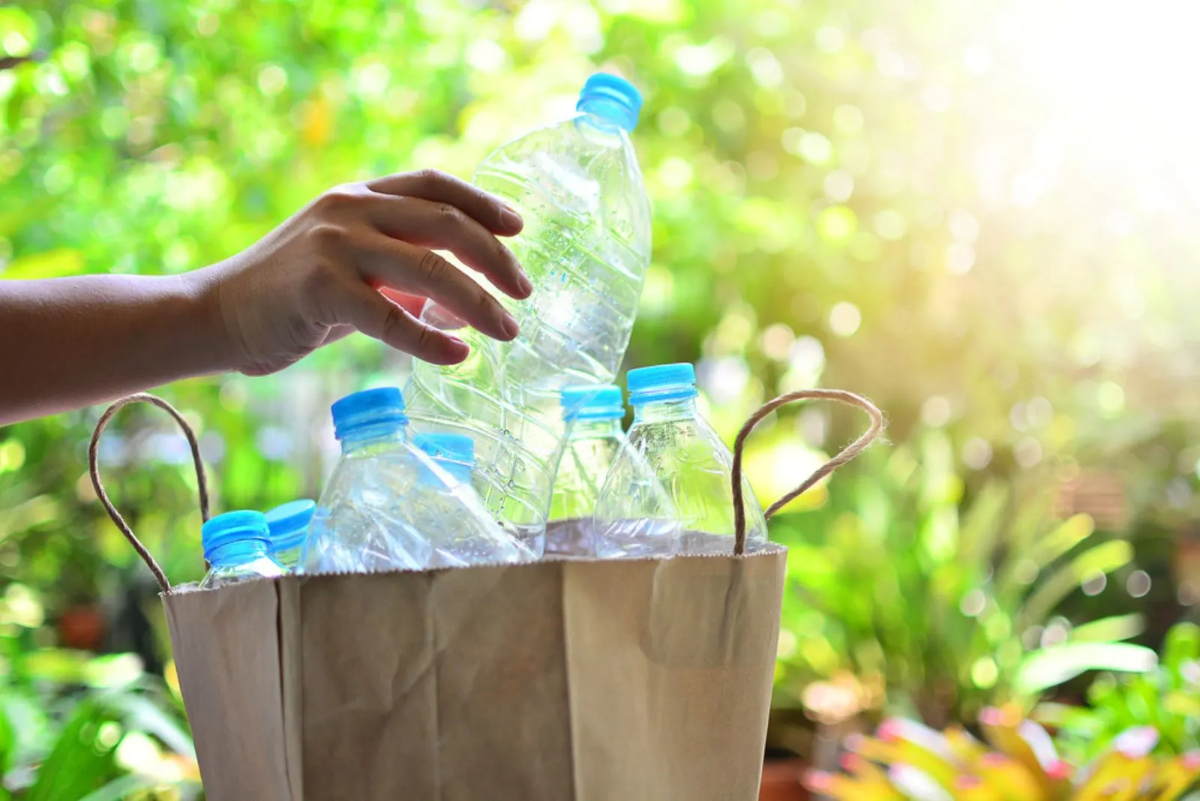 person hält leere plastikflasche für diy wasser tröpfchenbewässerung system