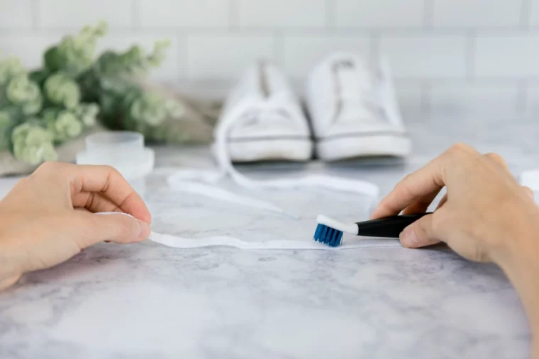 reinigung weißer schnürsenkel mit blauer zahnbürste